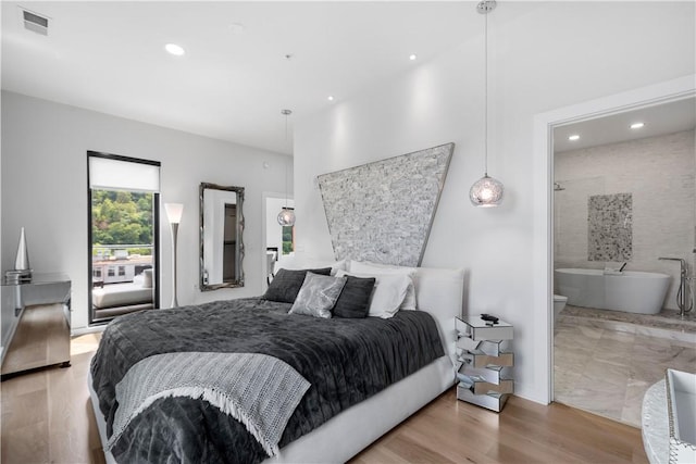 bedroom featuring wood finished floors, recessed lighting, and connected bathroom