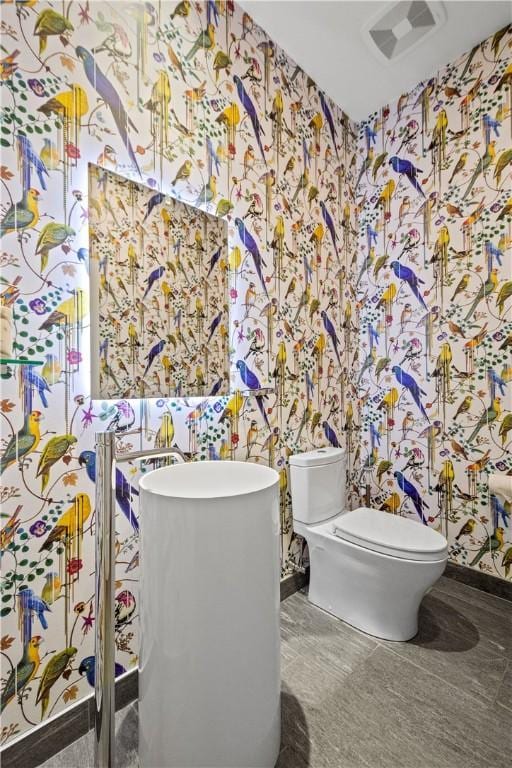 bathroom featuring toilet and wallpapered walls