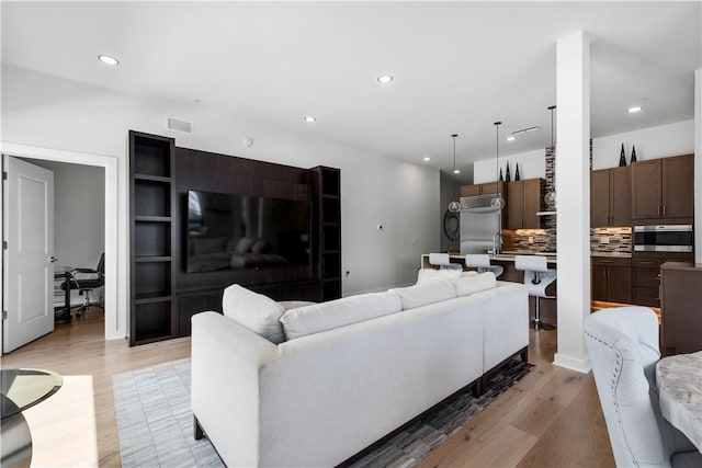 living area featuring light wood-style flooring and recessed lighting