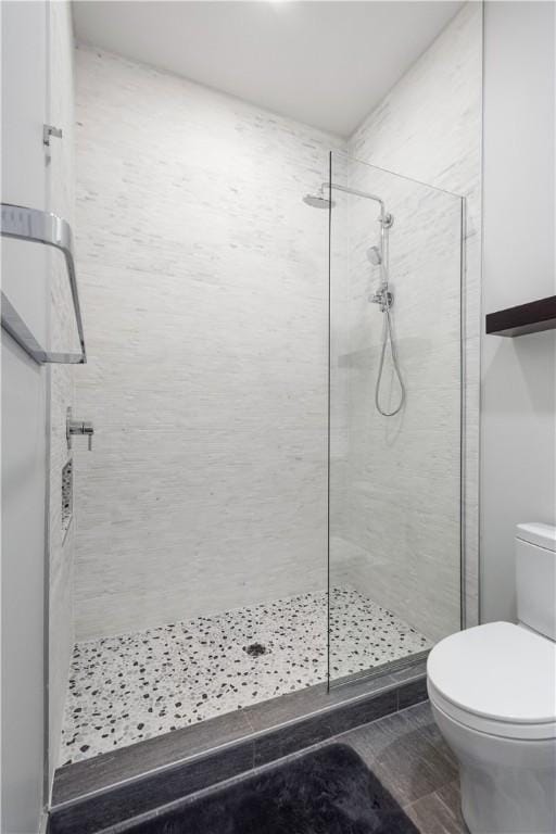 bathroom featuring toilet and a tile shower