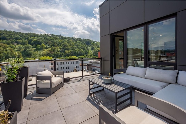 view of patio / terrace with an outdoor living space and a view of trees