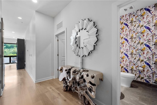 hall with light wood-style floors, recessed lighting, and baseboards