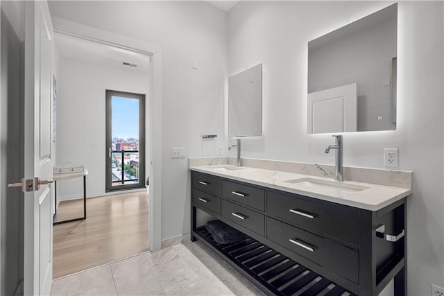 bathroom with double vanity and baseboards