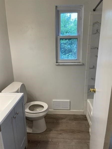 full bathroom with shower / bathing tub combination, hardwood / wood-style flooring, vanity, and toilet