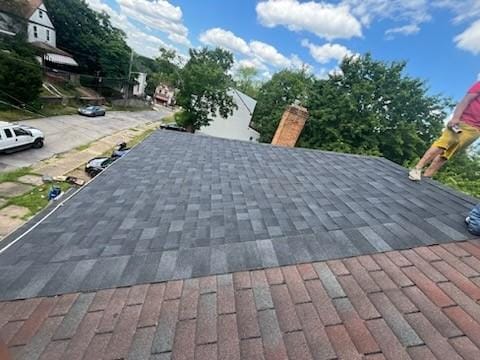 details featuring a chimney and roof with shingles