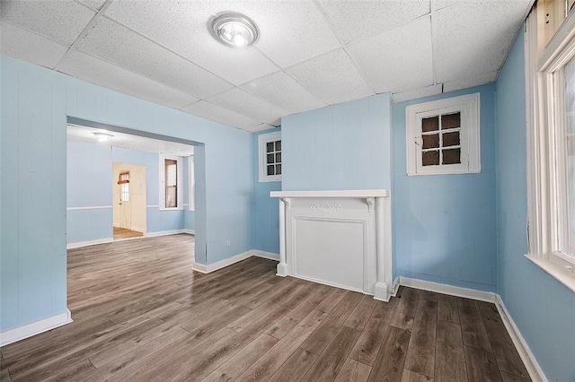 unfurnished room with hardwood / wood-style flooring and a drop ceiling