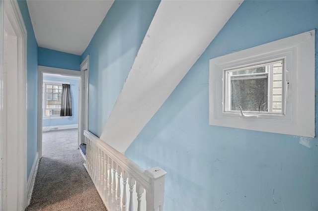 corridor with carpet floors and vaulted ceiling