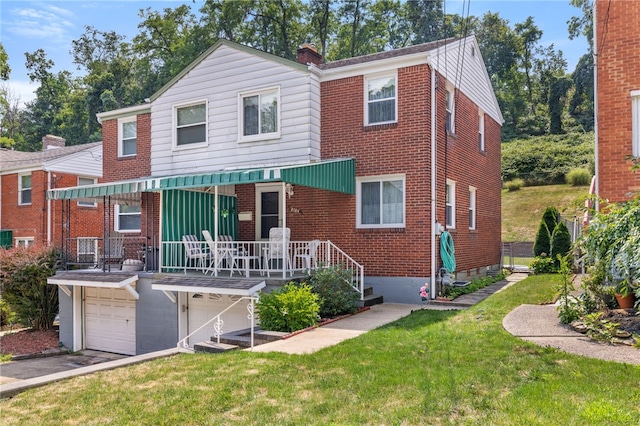 view of front of home featuring a garage, driveway, a chimney, a front lawn, and brick siding