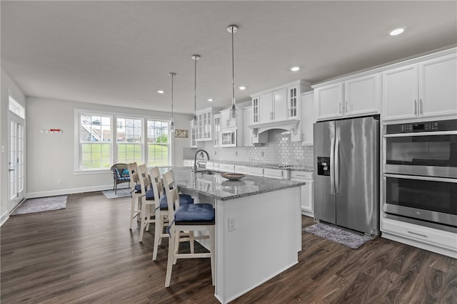 kitchen with dark hardwood / wood-style floors, stainless steel appliances, sink, and light stone countertops