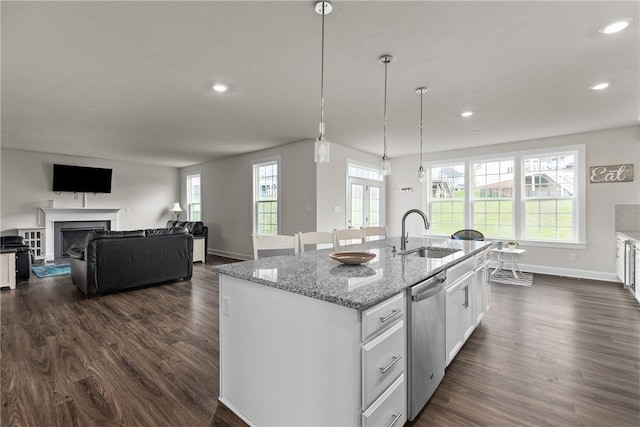 kitchen with dark wood-type flooring, dishwasher, a center island with sink, sink, and white cabinetry