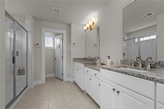 bathroom with walk in shower, tile patterned floors, and dual vanity