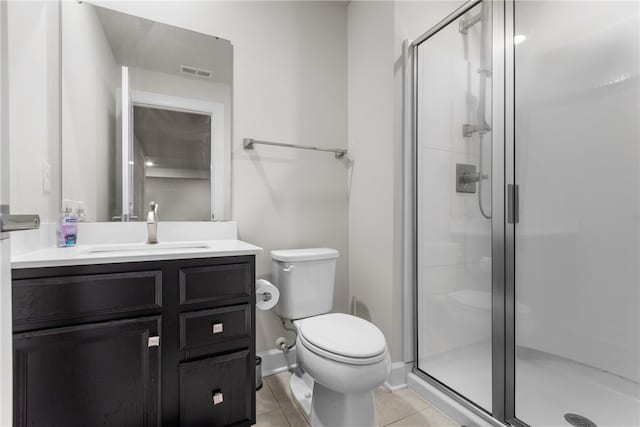 bathroom with a shower with shower door, vanity, toilet, and tile patterned flooring