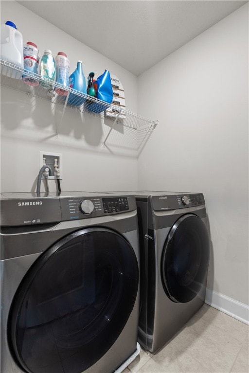 laundry area featuring washing machine and clothes dryer and light tile patterned floors