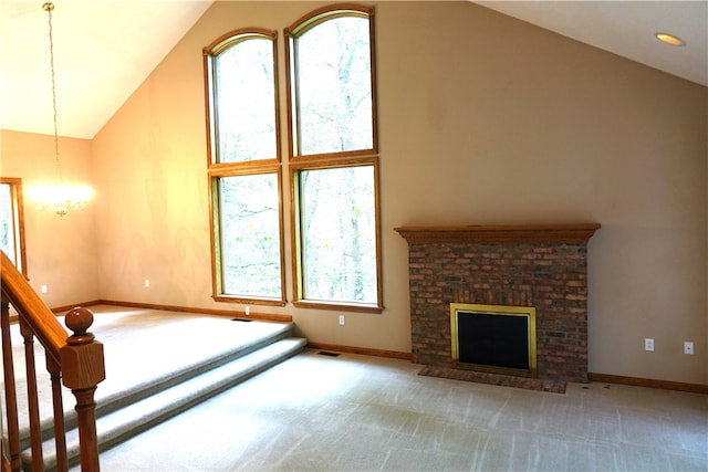 unfurnished living room with a fireplace, a healthy amount of sunlight, light colored carpet, and high vaulted ceiling