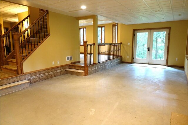 unfurnished living room with french doors and concrete floors