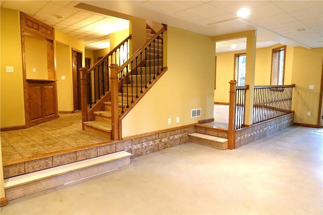 staircase with a paneled ceiling