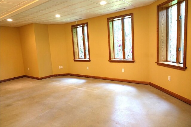 spare room featuring a paneled ceiling and plenty of natural light