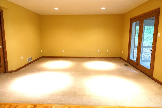 carpeted spare room with french doors and plenty of natural light