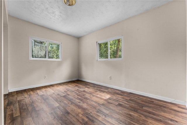 empty room with a textured ceiling and hardwood / wood-style floors