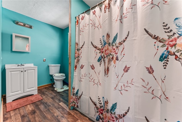 bathroom with toilet, vanity, and wood-type flooring