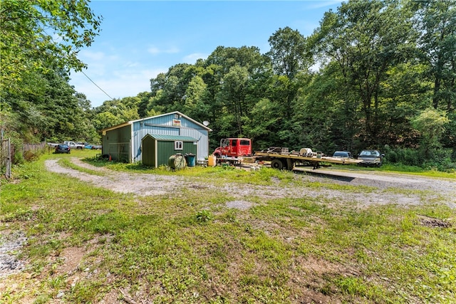 view of yard featuring a garage and an outbuilding