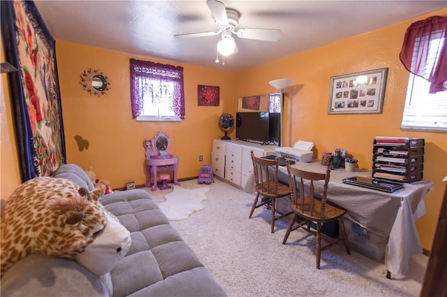 carpeted office space with a ceiling fan