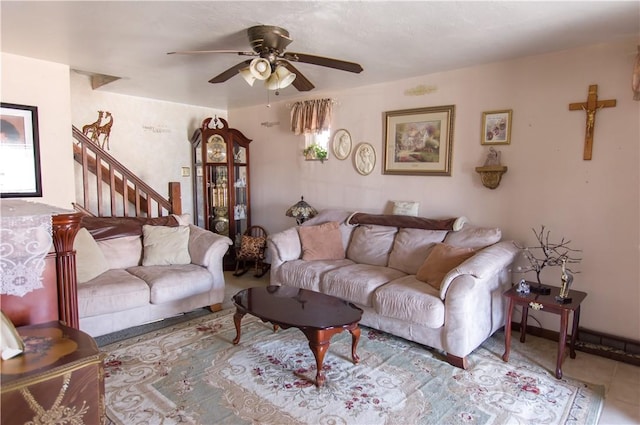 living room featuring tile patterned flooring, stairway, and ceiling fan