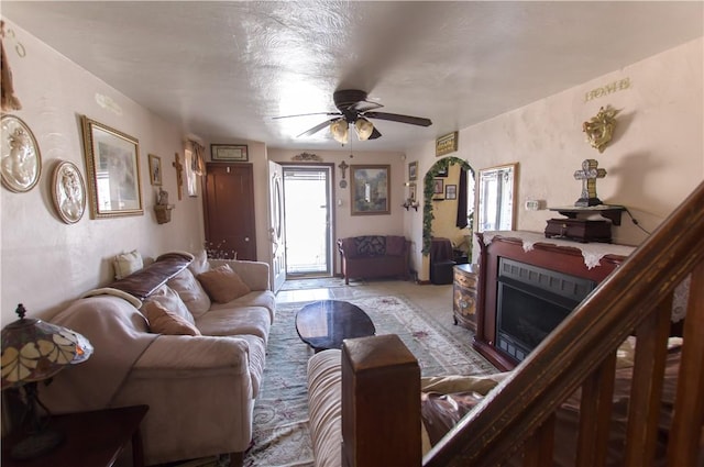 living room featuring ceiling fan and a fireplace