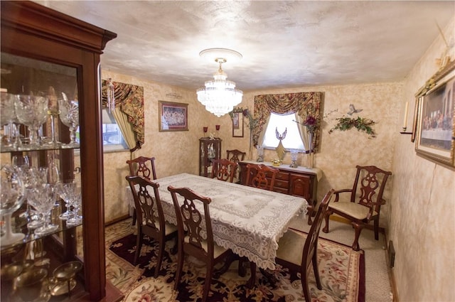 dining room featuring wallpapered walls and an inviting chandelier