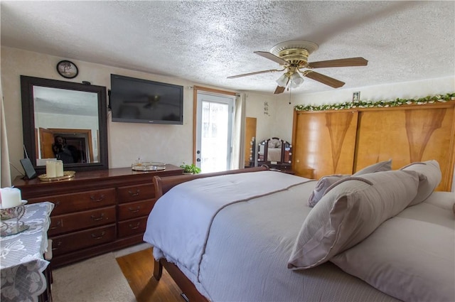 carpeted bedroom with a textured ceiling and a ceiling fan