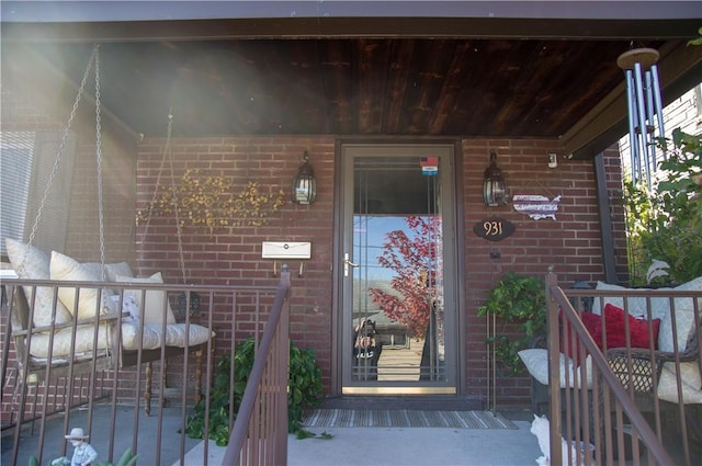 property entrance featuring brick siding and covered porch