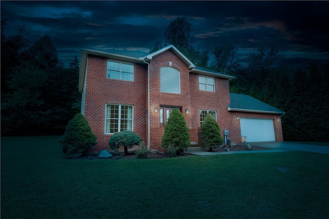 colonial home featuring a lawn and a garage