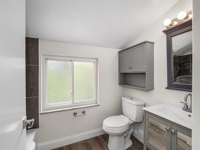 bathroom featuring lofted ceiling, wood-type flooring, vanity, and toilet