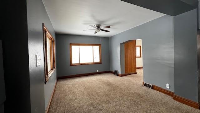 carpeted spare room with ceiling fan