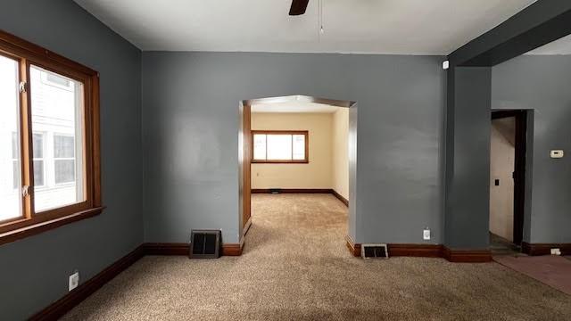 carpeted spare room featuring ceiling fan