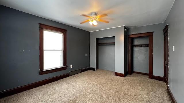 unfurnished bedroom with ceiling fan and light colored carpet