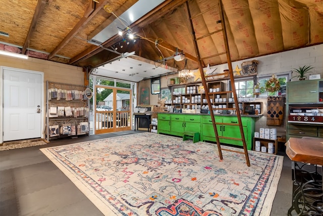 sitting room featuring vaulted ceiling, a wealth of natural light, and concrete floors