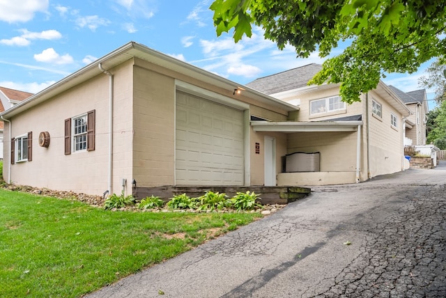 view of front of property with a garage, a carport, and a front lawn