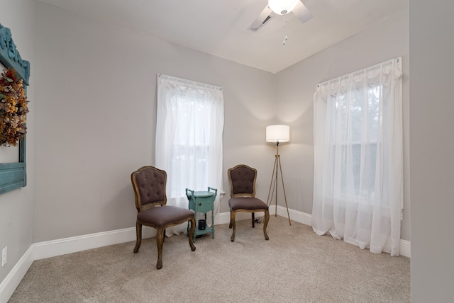 living area featuring ceiling fan and light colored carpet