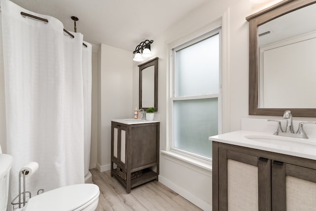 bathroom with toilet, vanity, and hardwood / wood-style flooring