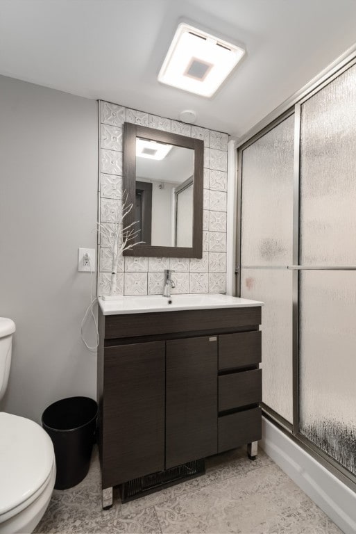 bathroom with toilet, tile walls, tasteful backsplash, tile patterned floors, and vanity