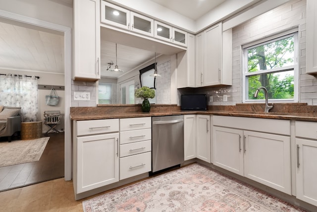 kitchen featuring decorative backsplash, white cabinets, dishwasher, sink, and light hardwood / wood-style flooring