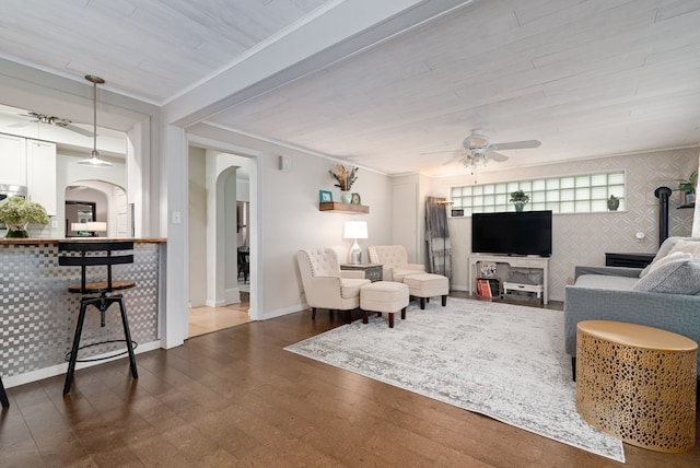 living room featuring ceiling fan, hardwood / wood-style flooring, and crown molding