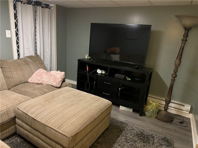 bedroom featuring a baseboard radiator, hardwood / wood-style floors, and a drop ceiling