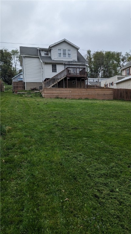 rear view of house featuring a yard and a wooden deck