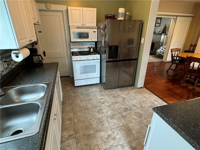 kitchen with white appliances, light wood-type flooring, sink, and white cabinets