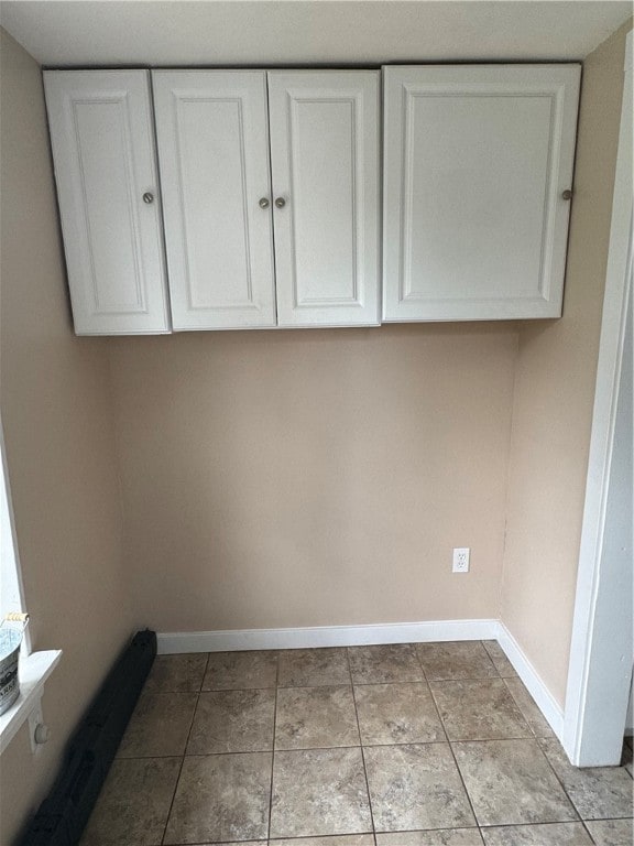 laundry area with light tile patterned floors