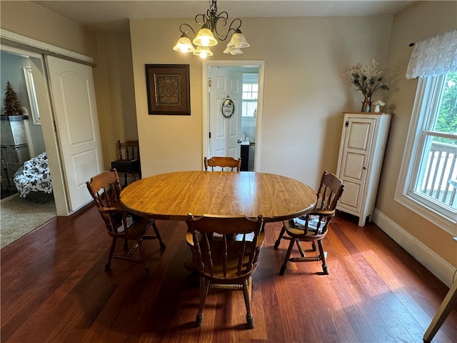 dining space featuring dark hardwood / wood-style flooring and an inviting chandelier