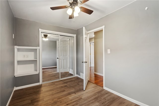 unfurnished bedroom with ceiling fan, hardwood / wood-style flooring, and a closet