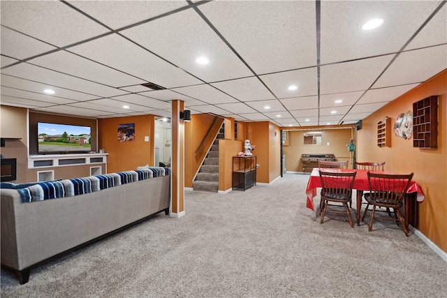 living room featuring light carpet and a paneled ceiling